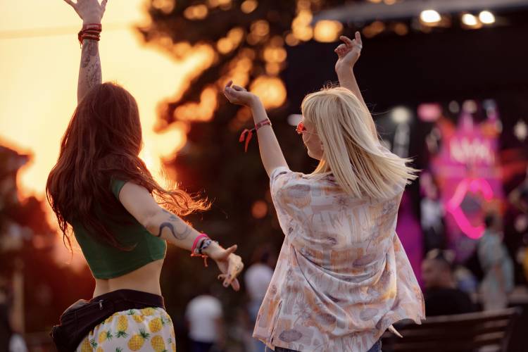 outdoor concert with focus on two girls dancing to music